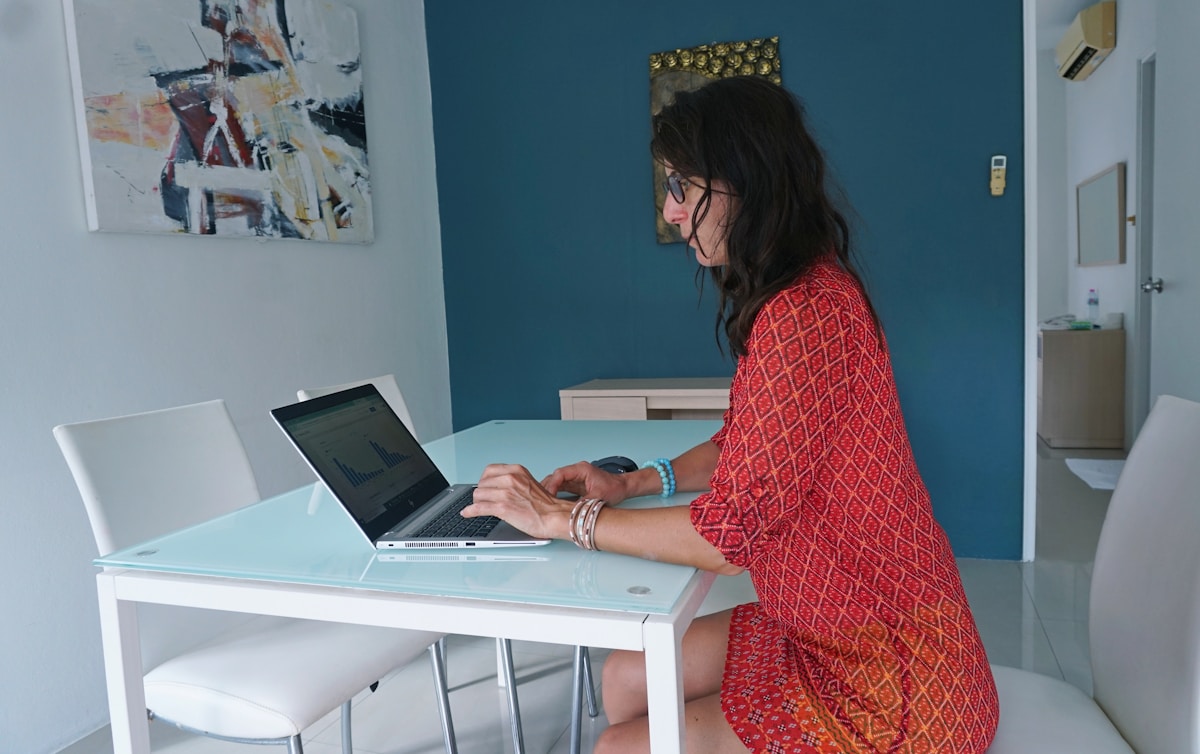 Woman works on laptop at a table.